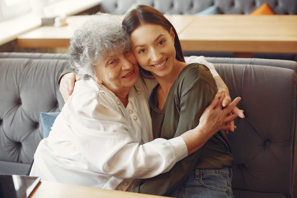 old woman and cargiver smilling together.